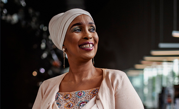 Kuvassa Farhia Abdi hymyilee ja katsoo sivulle